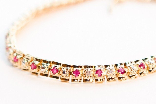 3.97 CTW Diamond & Ruby Tennis 18K Bracelet: Master jewelers designed your bracelet with: 29 pieces of GENUINE faceted Rubies. 29 pieces of GENUINE single cut diamonds, 0.21 carat Tw. 10.82 grams of sterling silver & brass layered with 18K gold 