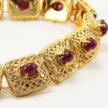 7 CT Cabochon Ruby Gold Bracelet: Master jewelers designed your bracelet with 14 pieces of GENUINE 5X4mm faceted oval cabochon rubies. 24 grams of brass layered with 18K gold. The length is 7 1/2 inches or 190mm. The width is 1/2 inch