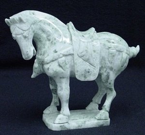 REAL JADE SADDLED TANG HORSE: This horse is made from one piece solid Taiwan jade. It appears light green with some area dark green. It comes with a wooden base. Size: L: 8", W: 3", H: 7"