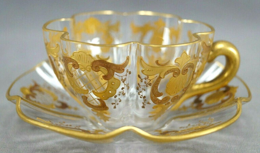 Antique Lobmeyr Bohemian Glass Tea Cup & Saucer A: Antique late 19th century clear lobed glass tea cup and saucer. Decorated with gold gilt floral and scrollwork designs. Gold gilding to the handle. Ground and polished base.Has some wear to the gildin