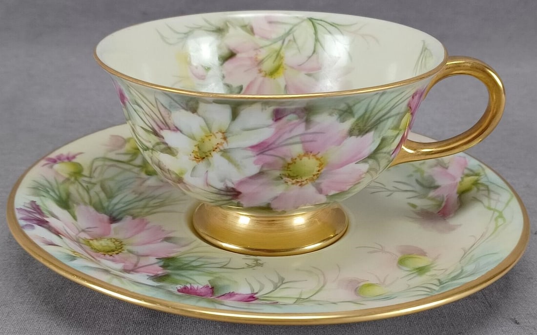 Eschenbach Hand Painted Flowers Cup & Saucer: Vintage German porcelain tea cup and saucer. Decorated with hand painted pink, purple, and white flowers tea cup and saucer. With gold gilding along the edge. The saucer is signed M. T. Kelley. Marked