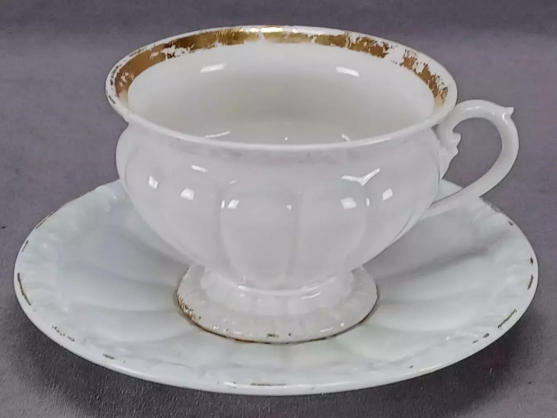 Meissen X Form Tea Cup & Saucer Circa 1831-1860: Antique German porcelain X Form footed tea cup and saucer. With gold gilding along the edge. Marked on the bottom with the blue hand painted underglaze crossed swords mark used by Meissen between 1824