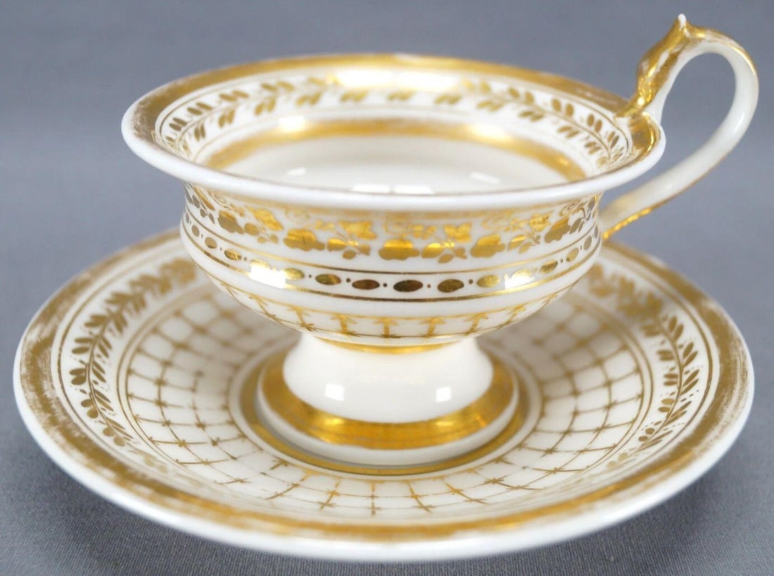 Old Paris Porcelain Snake Handle Tea Cup & Saucer: Antique Old Paris / Vieux Paris porcelain footed tea cup and saucer, with a snake / serpent handle. Nicely decorated in a gold gilt net, scrollwork and leaf pattern. Unmarked. Probably circa 1820s to