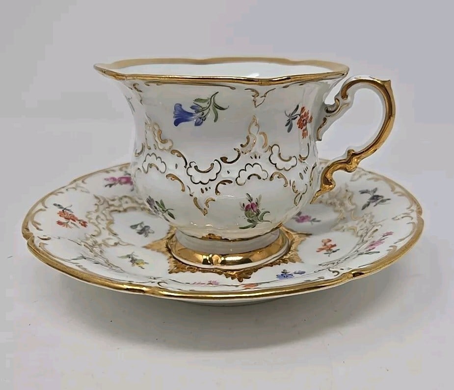 Meissen B Form Strewn Flowers Tea Cup & Saucer: Very nice condition B-Form Meissen tea cup and saucer set. Strewn wildflowers with delicate and heavy gold gilt design. Cup measures approximately 3 inches tall and 3 7/8 inches diameter. The saucer i