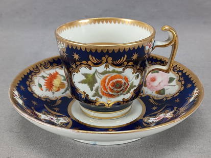 Coalport Hand Painted Coffee Cup & Saucer C1815-20: Antique British porcelain London form coffee cup and saucer. Decorated with hand painted flowers over white framed in gold gilding over a cobalt background. Scalloped gold gilding along the edge. Unma