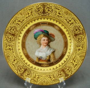 Dresden Hand Painted Yellow Lady Portrait Plate: Nice antique porcelain plate. Decorated with a hand painted portrait of a blonde lady with large green hat with pink feathers and a yellow and white gown over a white background with small gold dots.