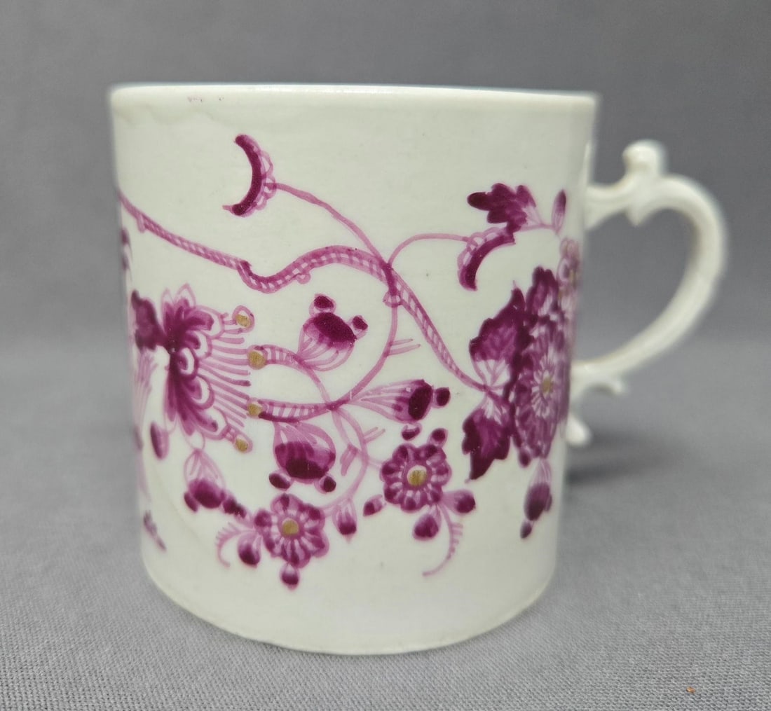 18th Century Ludwigsburg Coffee Can: Antique, late 1700s, Ludwigsburg coffee can. It has a hand painted purple floral pattern with gold accents in flowers on a white cup. There is a crack that shows through on both sides as shown. No oth
