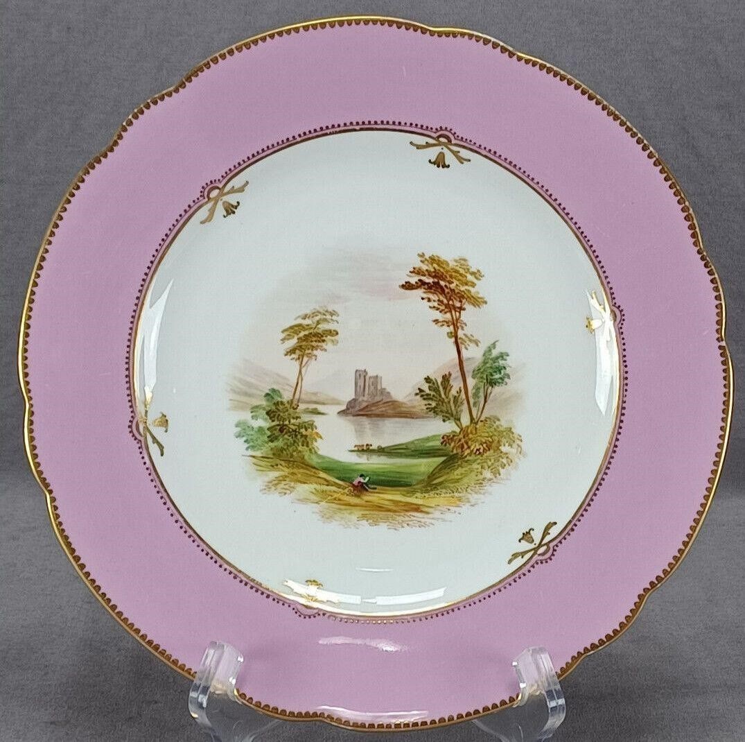 Brown Westhead Moore Pink Castle Landscape Plate: Nice antique British bone china plate. Decorated with a hand painted landscape with trees in brown and green, a body of water, a a castle, and a man sitting at the bottom of a hill. Has a pink or pale