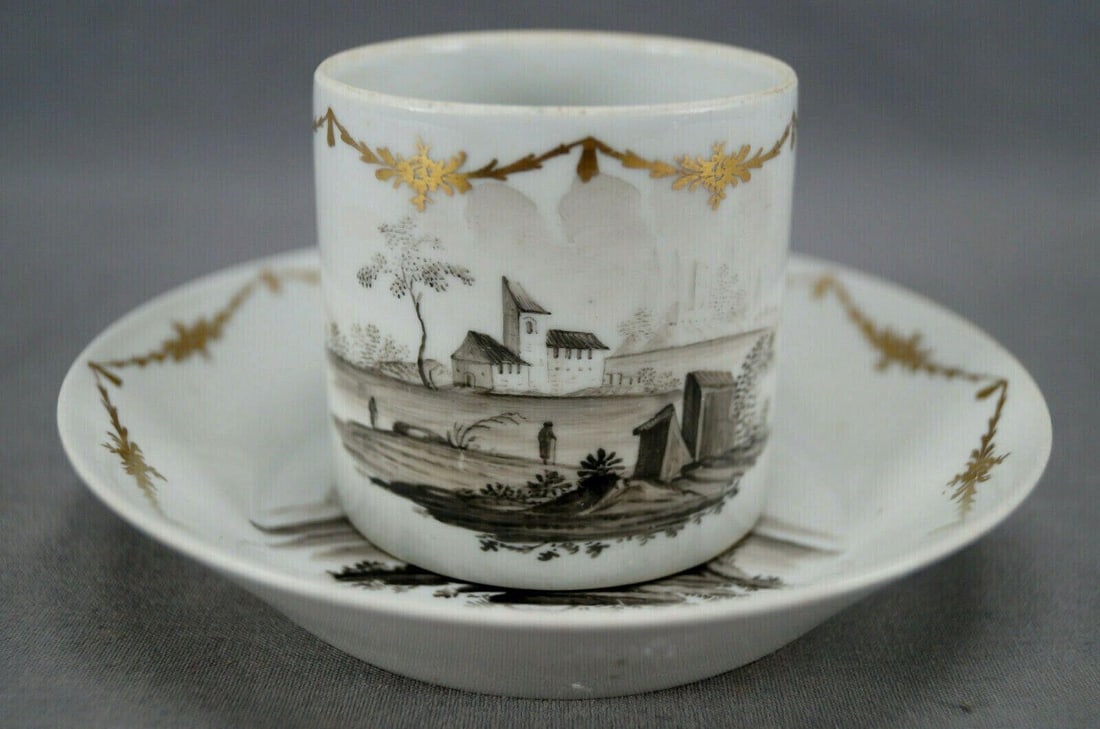 18th Century Wallendorf Hand Painted Coffee Can: Rare 18th century Wallendorf Thuringia Germany coffee can and saucer. Decorated with a hand painted black and white landscape scene with buildings, trees, hills and people. With gold gilt floral