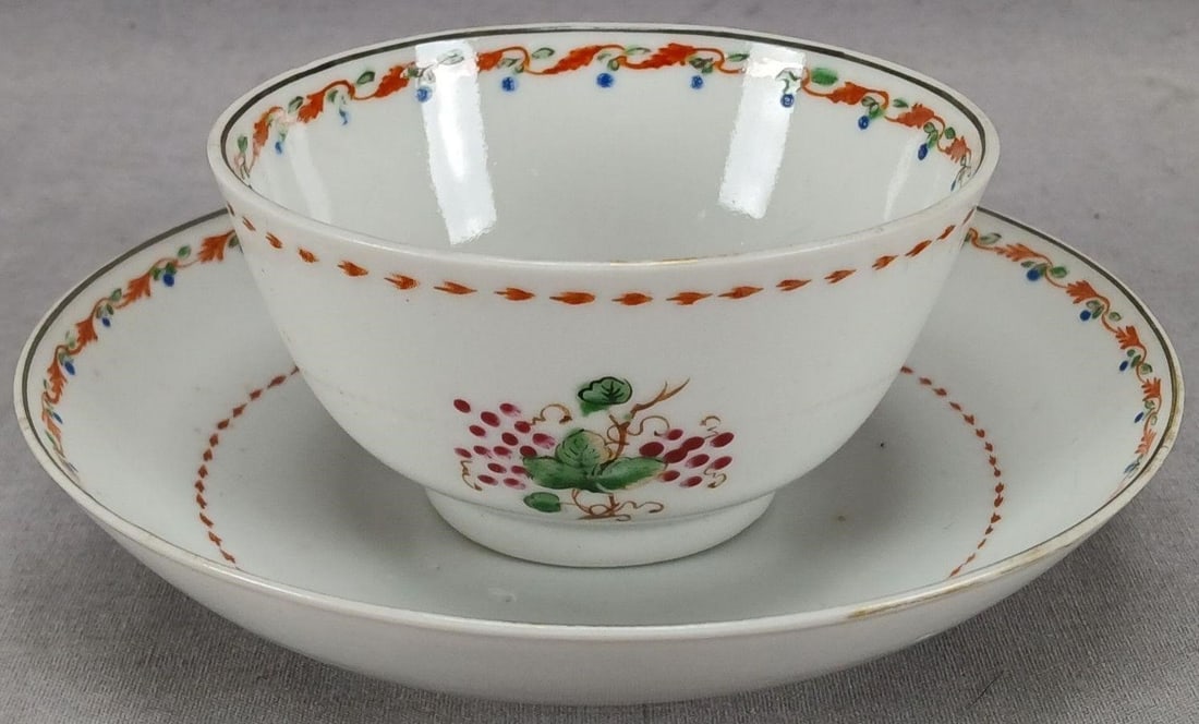 18th Century Chinese Export Tea Bowl & Saucer: Antique 18th century Chinese Export porcelain tea bowl and saucer. Decorated with hand painted puce grapes with gold highlights. Iron red arrow band on the outside of the tea bowl and around the cente