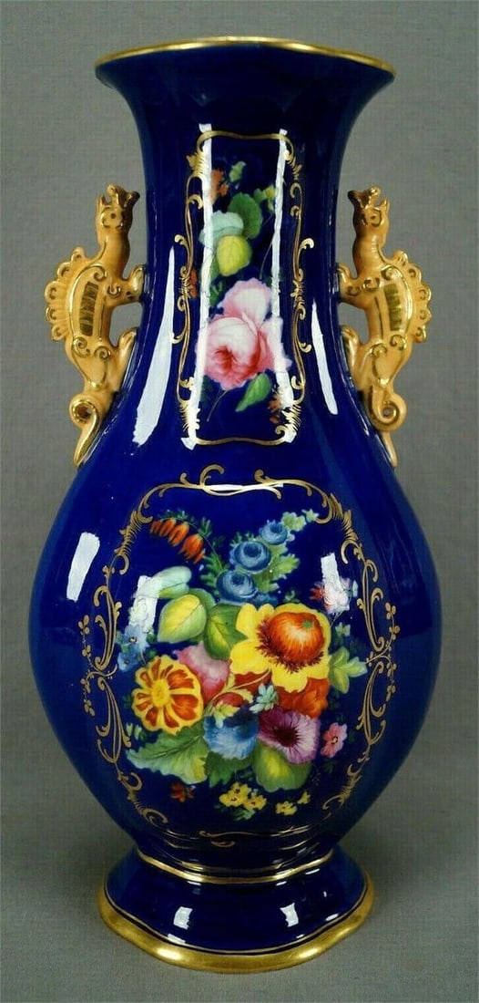 Minton Chinese Form Dragon Handle Vase 1820 B: Rare Chinese form dragon handle bone china vase. Has an overall cobalt blue background. Decorated with hand painted purple, pink, blue, yellow, and orange flowers on each side framed in gold gilt flor