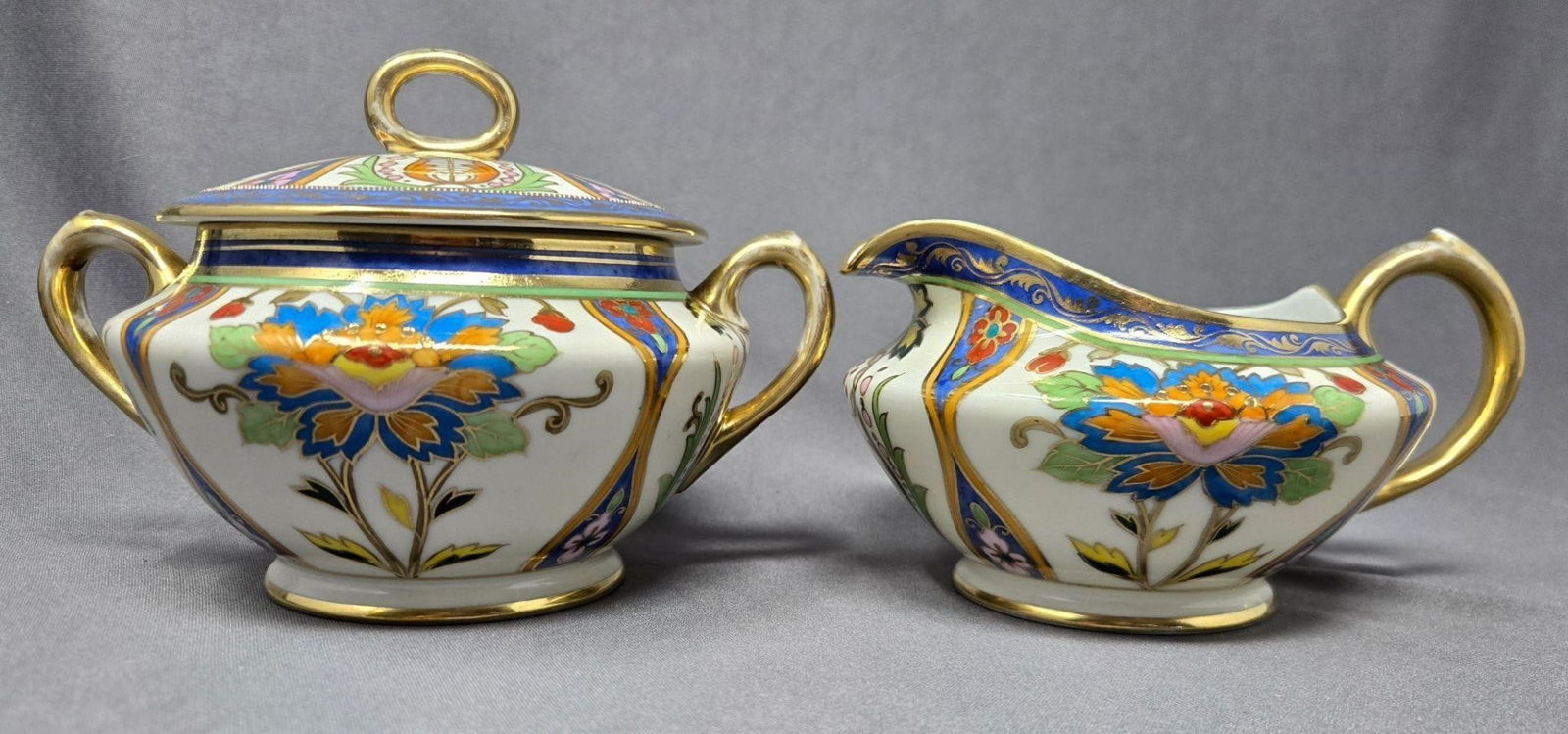 MoriMura Brothers Creamer and Sugar Bowl 1911-21: Hand Painted Nippon Morimura Brothers creamer and sugar set. Very nicely done floral and leaf pattern. No chips or cracks there is some gold loss on handles. Approximate measurements: The creamer is 2