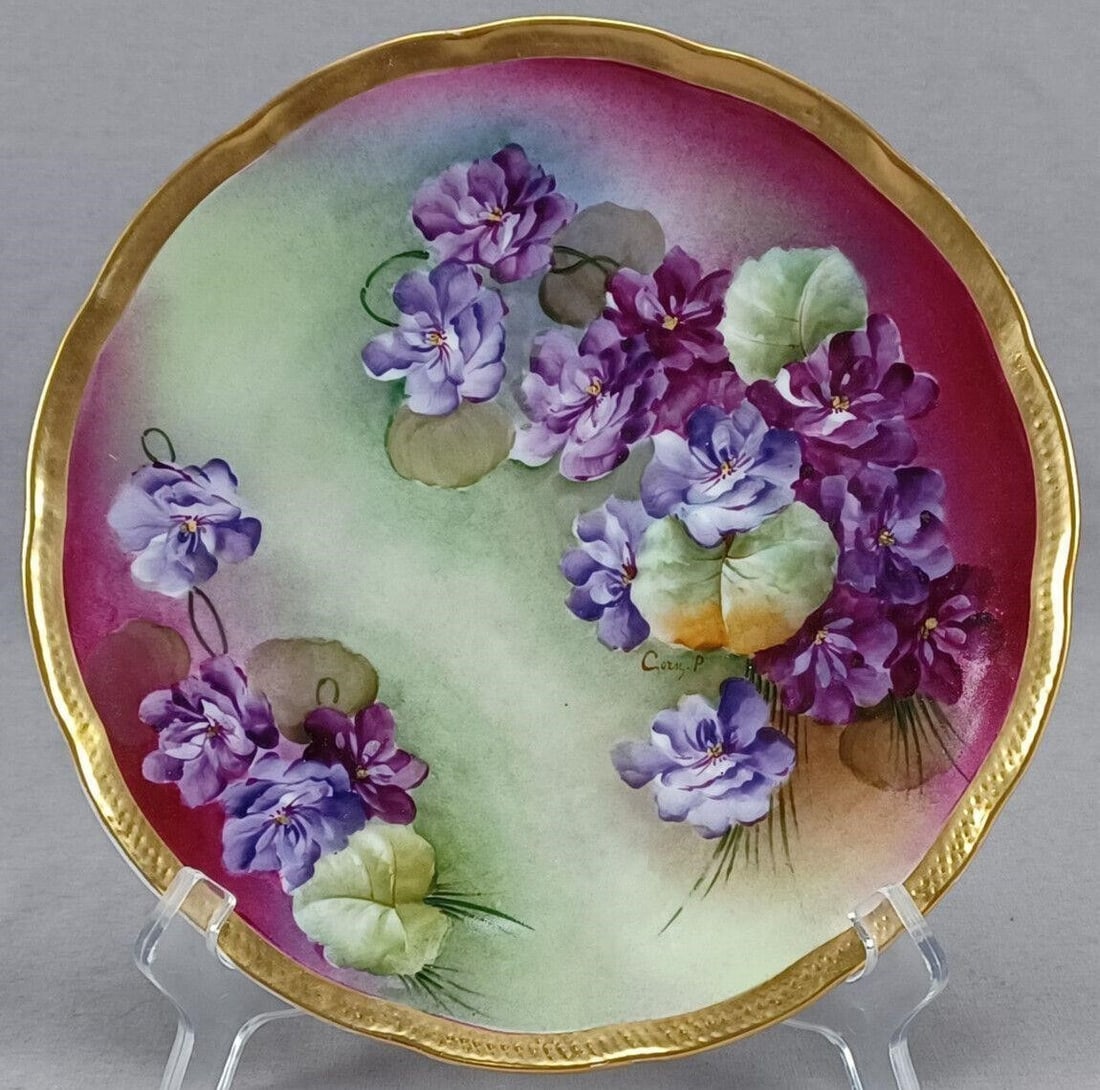 Ginori Italy Signed Hand Painted Violet Plate: Nice antique porcelain plate. Decorated with hand painted violet flowers over a purple and green background. With gold gilding along the edge. Signed by the artist. Marked on the bottom Ginori in gree
