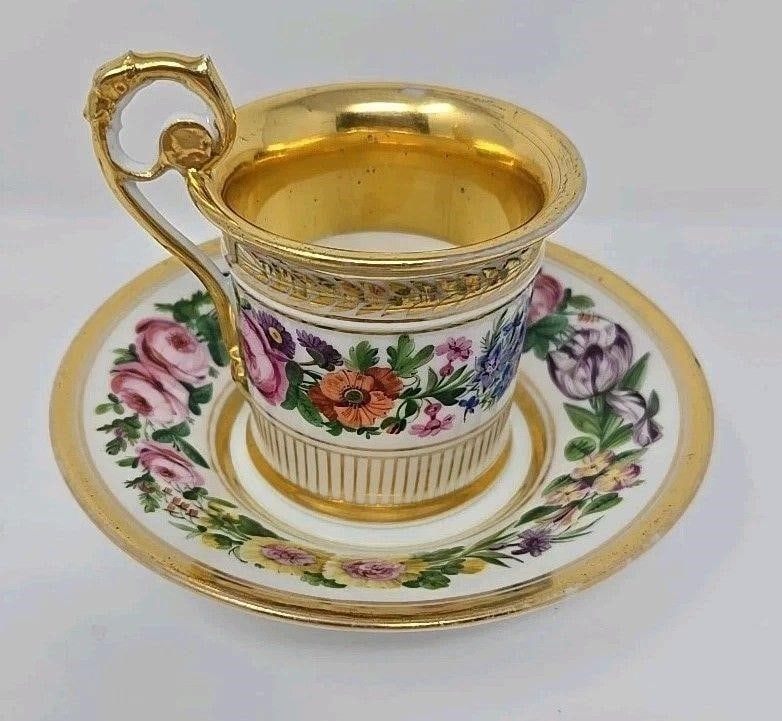 Old Paris Porcelain Cup & Saucer Serpent Handle: Old Paris Porcelain cup and saucer. Circa 1820s. It has a molded serpent handle with a floral band and gold laurel band. Approximate measurements: The saucer is 5 1/4 inches in diameter and is 1 1/8 i