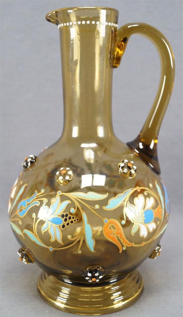 Theresienthal Floral Enamel Blown Amber Glass Jug: Nice late 19th or early 20th century hand blown Theresienthal pitcher or jug. With applied prunts with orange and white enameled beading. Hand enameled Art Nouveau floral scrollwork in shades of blue,