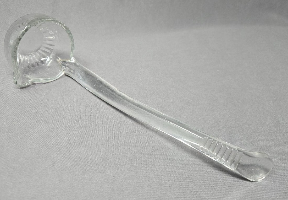 19th C Anglo Irish Hand Blown Glass Ladle: Hand blown, early to mid 1800s ,Anglo Irish punch bowl spouted ladle and applied handle. It has a polished pontil on bowl with cuts radiating out. It also has line cuts on the handle. Measures approxi