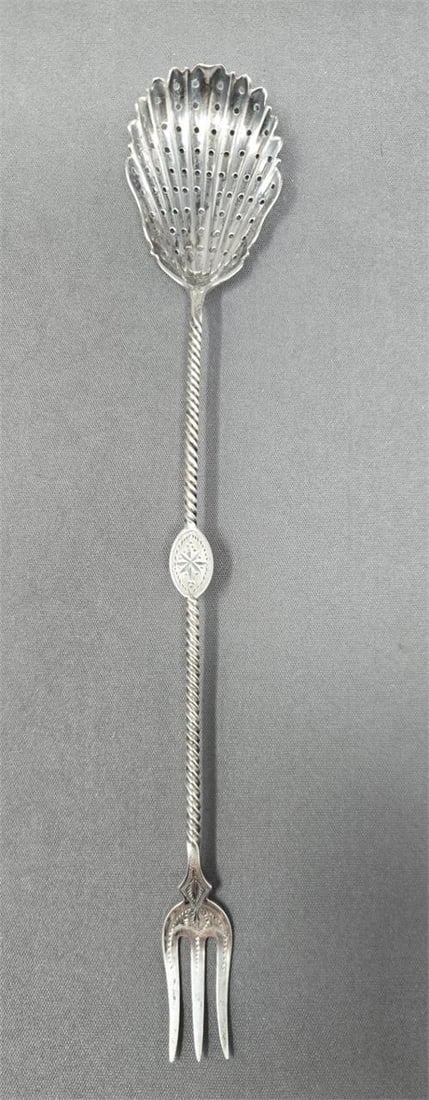 Bright Cut Silver Olive Fork / Spoon: Unmarked silver combination olive fork / spoon. It is bright cut with a twist handle and monogrammed in middle of handle on back. C. 1850. Measures approximately 9 3/8 inches long.We can offer