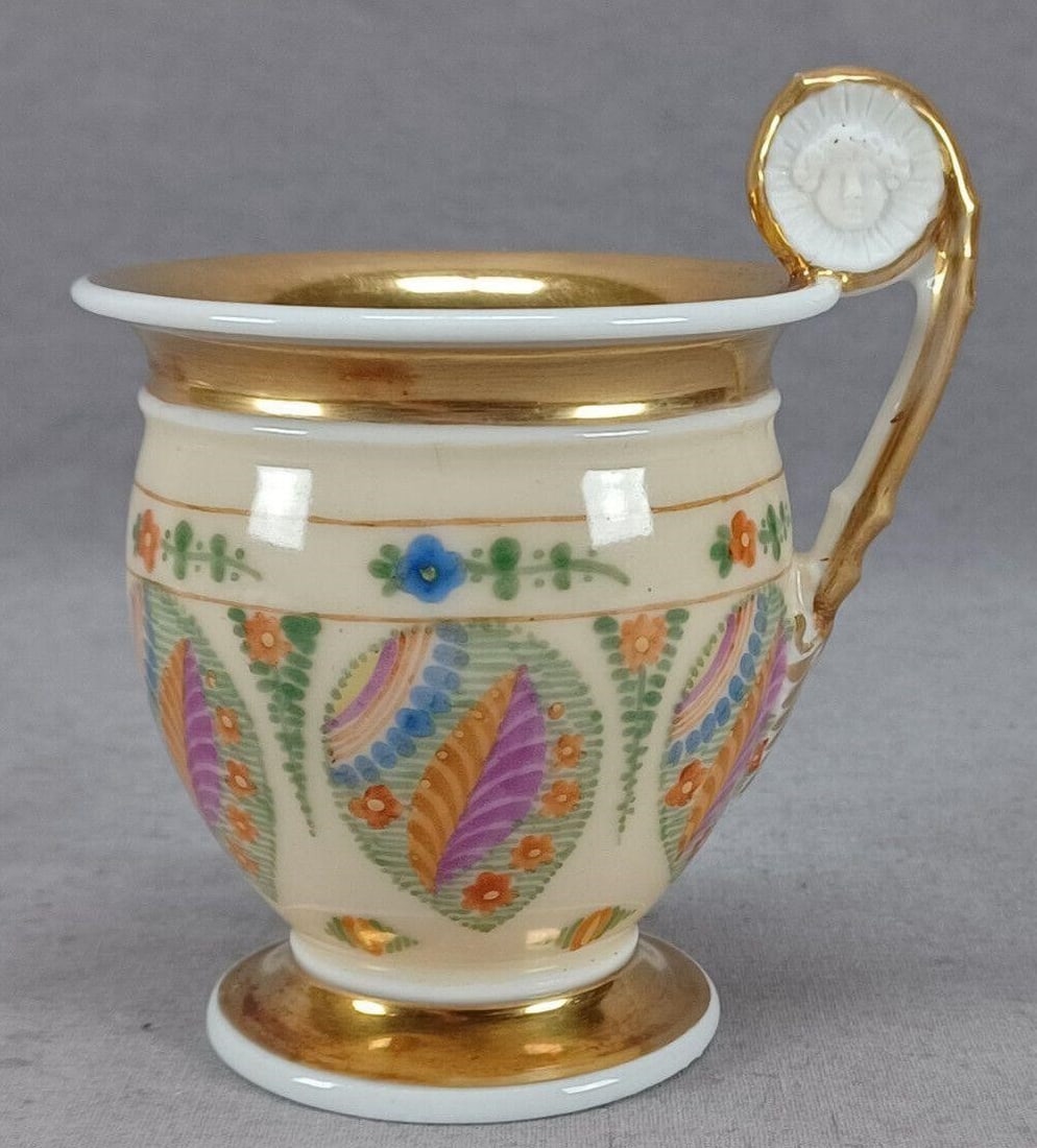 Old Paris Floral Cream Gold Empire Form Cup C1820: Nice antique Old Paris / Vieux Paris French porcelain empire form cup. With bisque figural head and gilt handle. Decorated with hand painted multicolor flowers and over a cream background. Gold gildin
