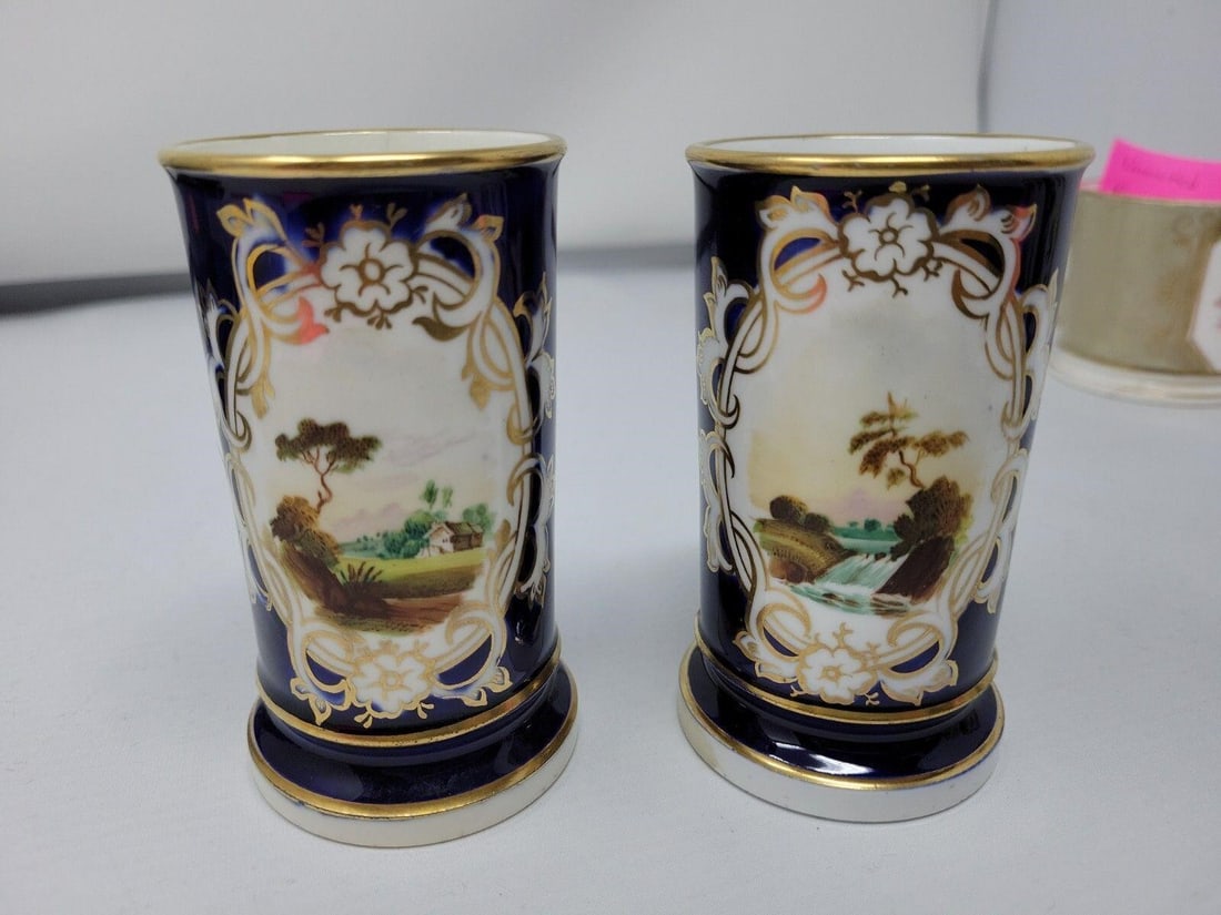 Unmarked Porcelain Cobalt Spill Vases Rural Scenes: Pair of Unmarked porcelain Cobalt Blue Spill Vase with Rural Scenes 19th Century. Small hairline Crack on one, other imperfections are shown in pictures. They are 2.25 inches by 4 inches each.We can o