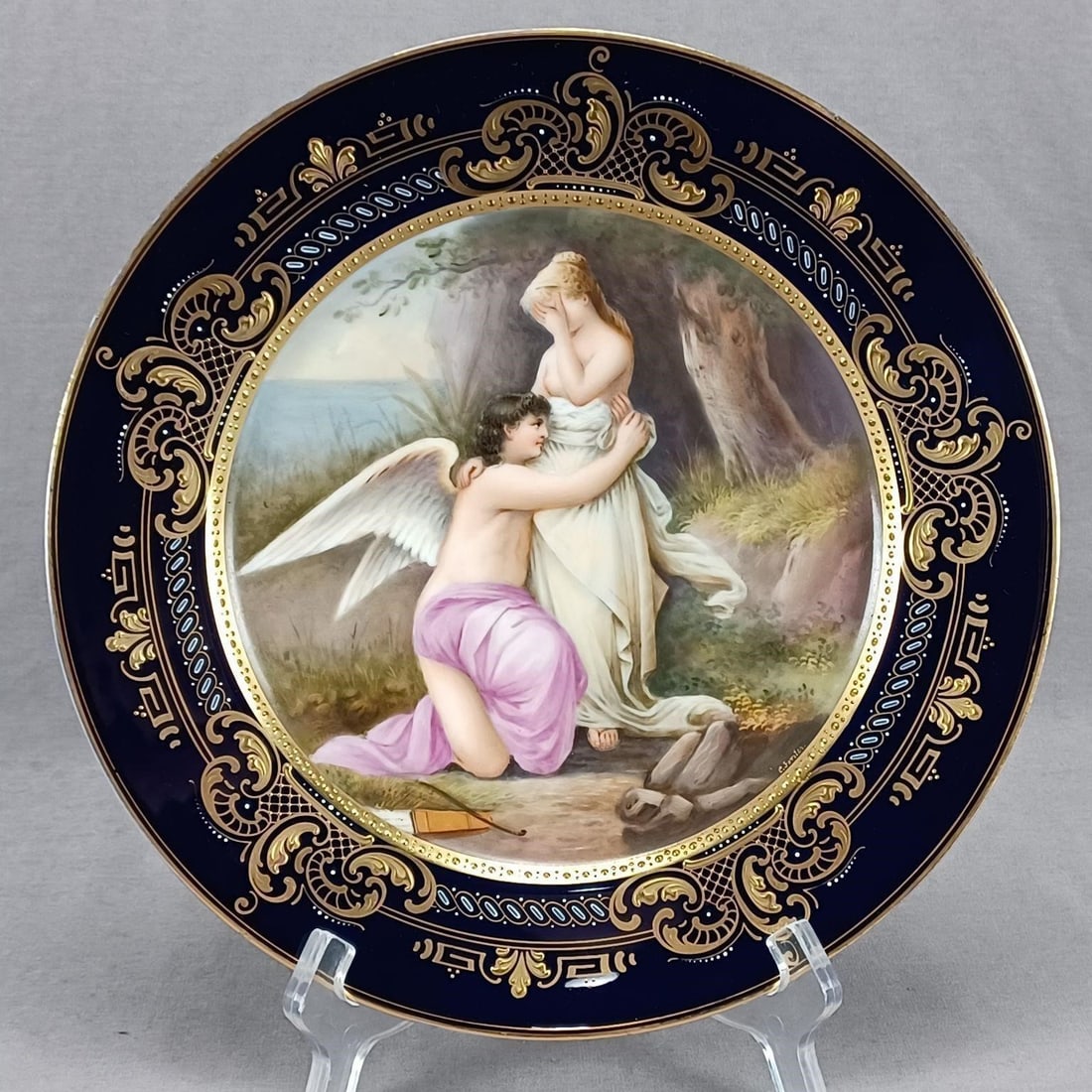 Royal Vienna Style HP Cupid & Psyche Plate: Nice antique Royal Vienna style plate. Decorated with a hand painted Neoclassical scene depicting Cupid's Farewell to Psyche. Signed by the artist C Forster. Gold gilding with gold beading along the i