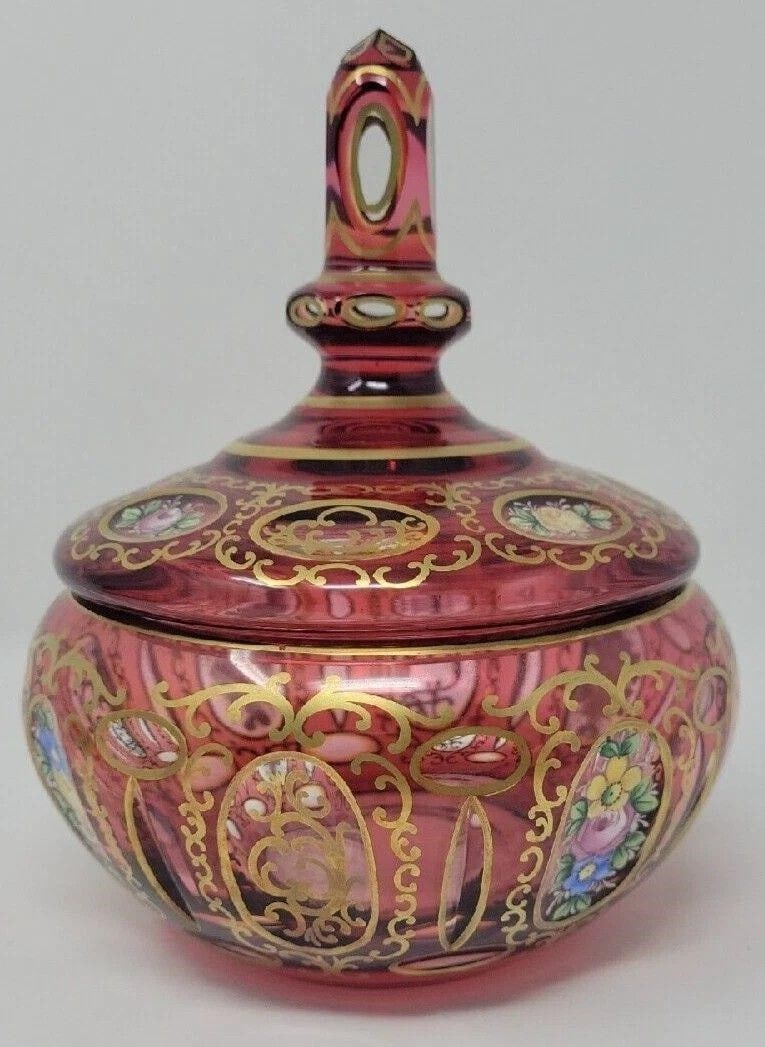 Bohemian Czech Cranberry Glass Covered Candy Dish: This antique Bohemian Czech candy dish is a beautiful piece of hand painted glass. The round dish features a cut to clear design with thumbprints and a painted flowers and scrollwork pattern. Measurin