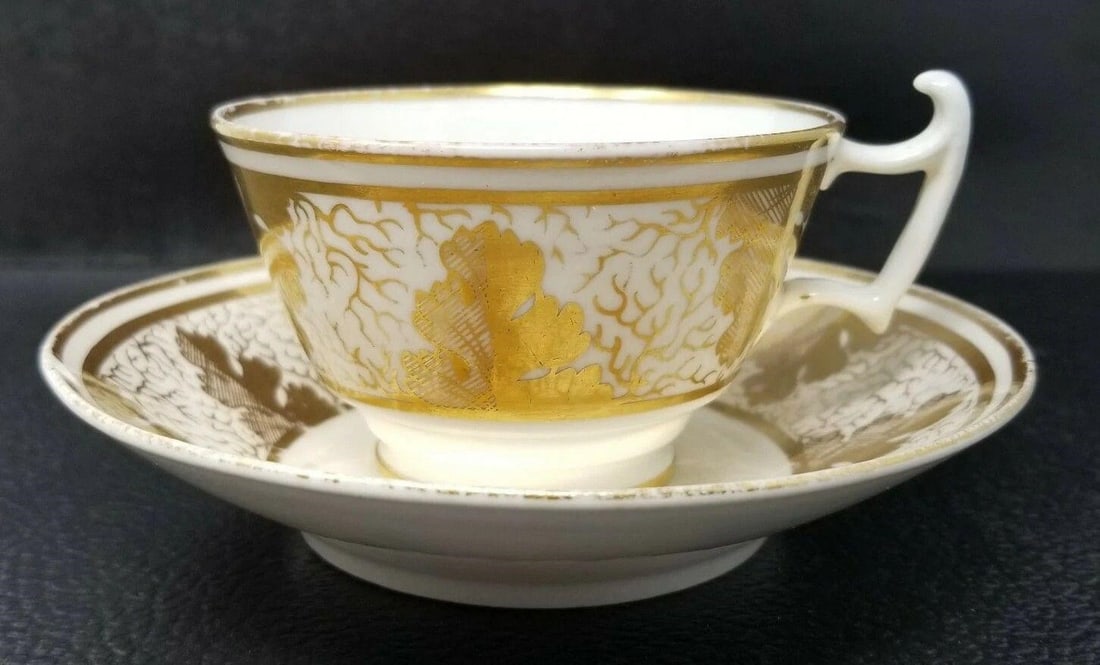 Coalport Hand Painted Oak Leaf Tea Cup & Saucer: Coalport Hand Painted Gold Oak Leaf tea cup & saucer. Circa 1820. Minor loss of gold, commensurate with age and some crazing. The tea cup has no chips or cracks. The saucer has a 1/4 inch chip and a s
