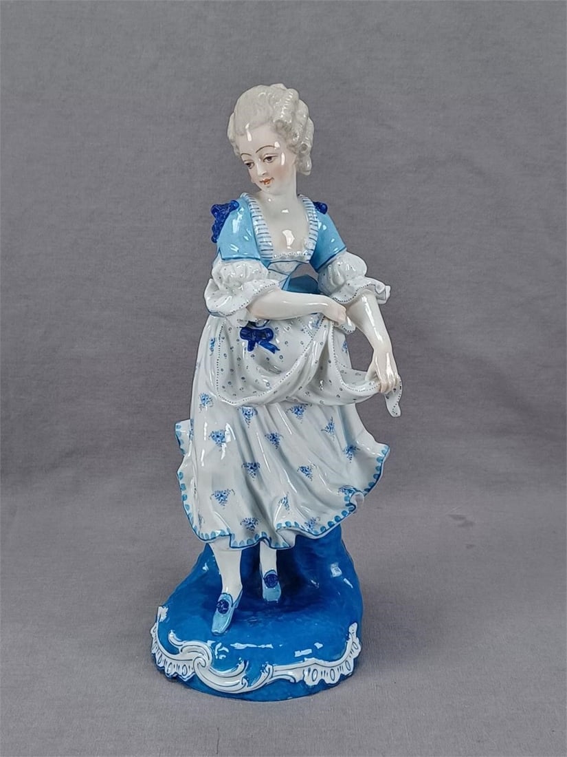 Antique French Hand Painted Porcelain Figurine: Nice antique 19th century French porcelain figurine. Hand painted in blue and white. Has a hand painted underglaze blue hayfork mark on the base.There is a chip to either a bow or a flower on the neck
