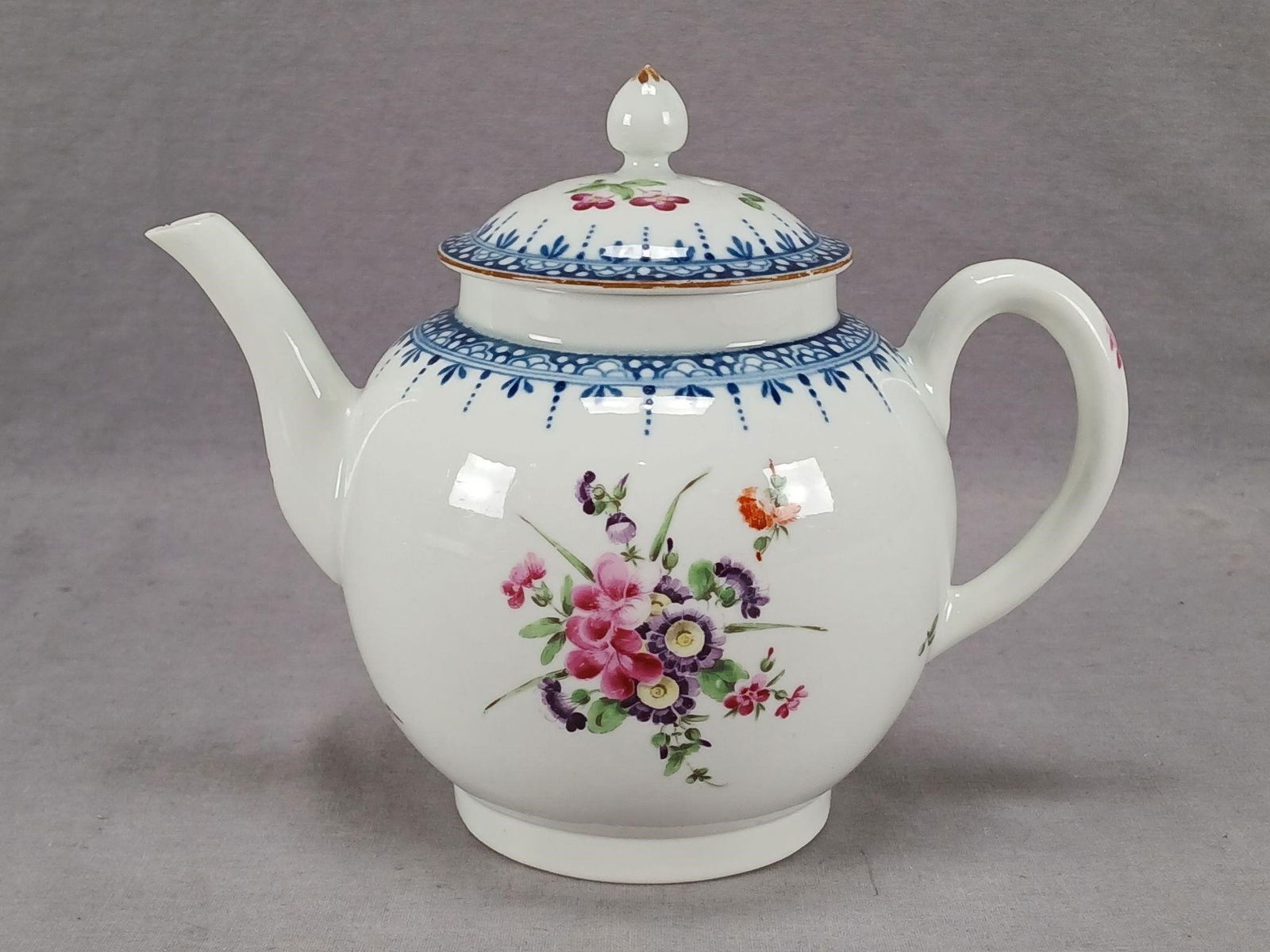 18th Century Worcester Hand Painted Teapot: Antique 18th century British Worcester porcelain teapot. Decorated with hand painted purple, pink, and orange flowers. Has a blue printed border. With brown trim along the edge. Unmarked. Circa 1770.H