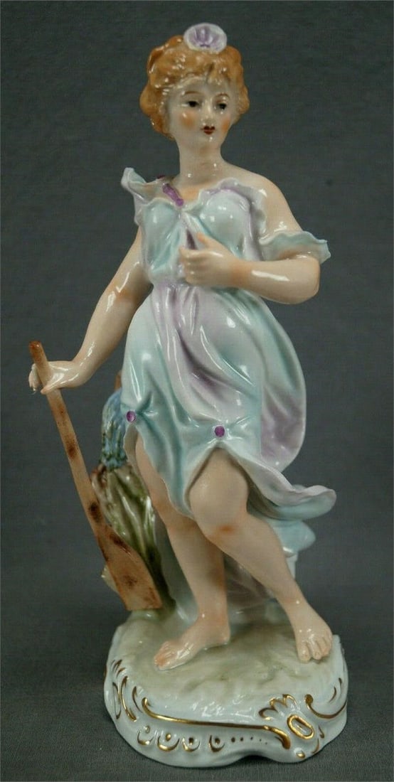 Sitzendorf Germany 8 1/8" Tall Nereid Figurine: Nice porcelain figurine depicting a Greek Nereid. Hand painted with a pink and blue dress. She has a pink shell in her hair and an oar in her right hand. There is a barrel of water behind her. Marked