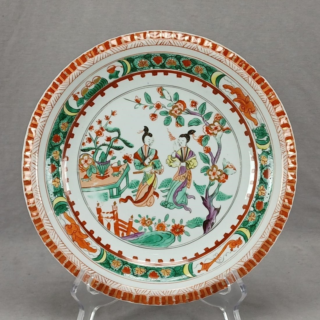 18th Century Derby Hand Painted Famille Verte Dish: Antique 18th century British Famille Verte porcelain plate / dish. Hand painted with two ladies in a Garden in green, orange, red, yellow, and purple with gold highlights. Unmarked. Produced by Derby.