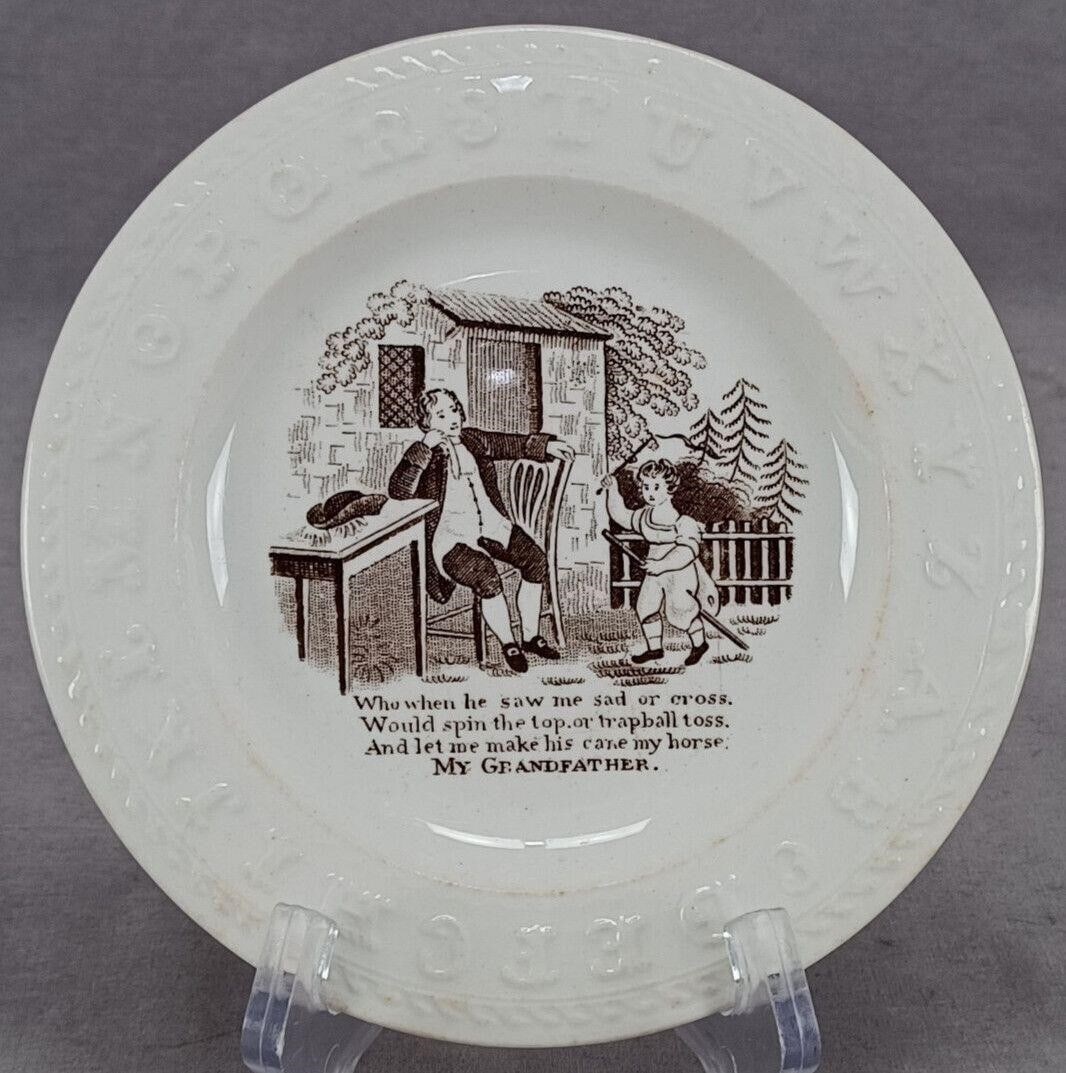 19th Century Who When He Saw Me ABC 6 Inch Plate: Antique 19th century British earthenware ABC Plate. Decorated with a scene in dark brown transfer with "Who when he saw me sad or cross, would spin the top or trapball toss, And let me make his cane m