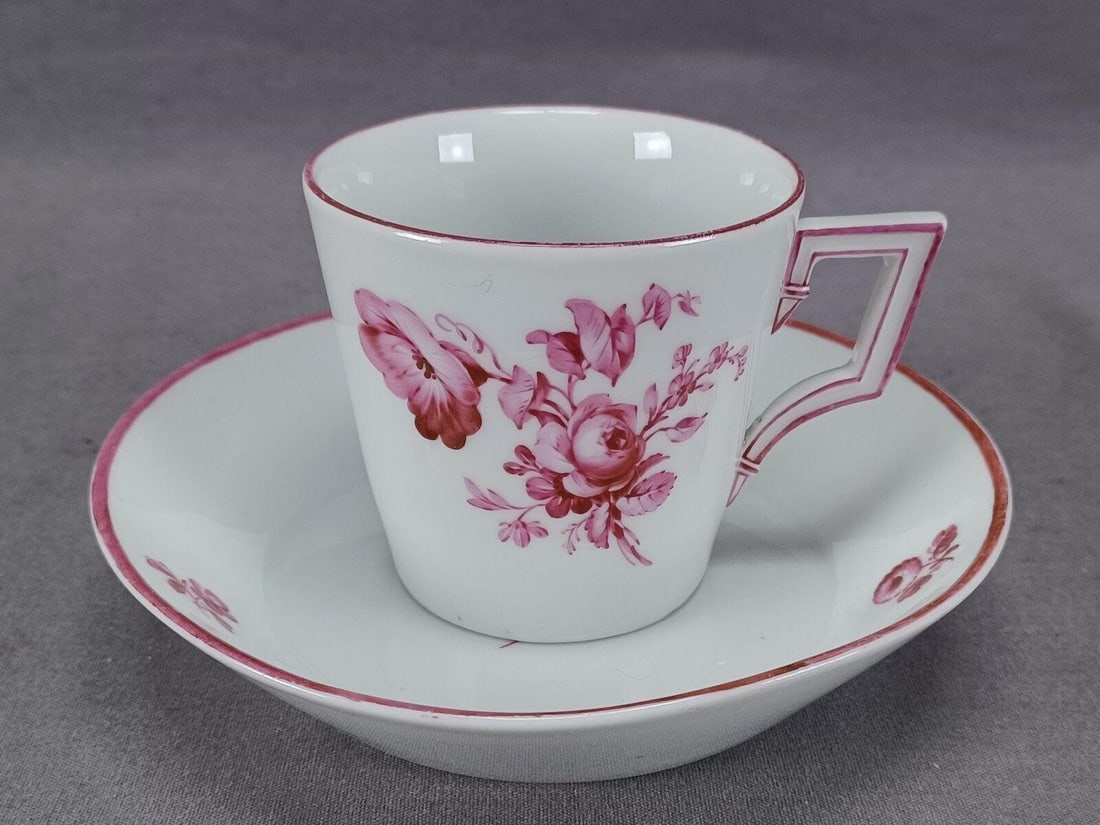 18th Century KPM Berlin Floral Coffee Cup & Saucer: Late 18th century German KPM Berlin porcelain coffee cup and saucer. Decorated with hand painted puce flowers and trim. Marked on the bottom with the hand painted blue scepter mark used by KPM Berlin.