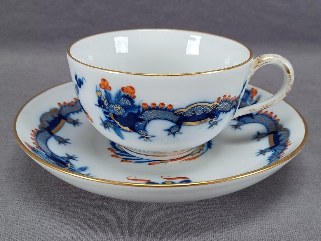 Meissen Cobalt Red Court Dragon Tea Cup & Saucer: Nice antique German porcelain tea cup and saucer. Decorated in the Court Dragon pattern in hand painted underglaze cobalt with red and gold highlights. Gold gilding along the edge. Marked on the
