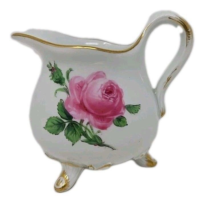 Meissen Footed Creamer Pink Rose Pattern: Meissen Pink Rose Pattern footed creamer. Circa 1924 to 1933. Measures approximately 2 3/8 inches tall and 2 1/8 inches wide without handle. Very good condition without chips, cracks or scratchesWe