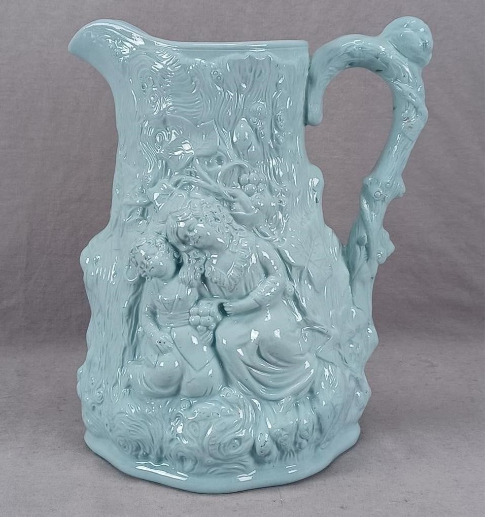 Cork & Edge Blue Glazed Babes in the Woods Jug: Nice antique British relief molded Babes in the Wood blue glazed stoneware jug. Unmarked. Probably Cork & Edge. Circa 1855.Has a chip to the nose of one of the figures, but otherwise good condition.Me