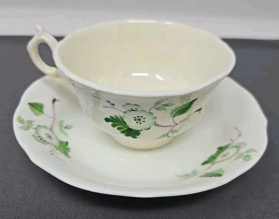 British Bone China Floral Sprigs Tea Cup & Saucer: British antique bone china teacup and saucer set. It has green and purple flower sprigs. Circa 1830s. No marks on either. Only minor scratches from use. The inside of the cup is a bit darker than rest
