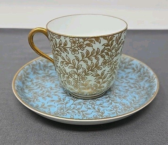 Royal Worcester Demitasse Cup And Saucer: Royal Worcester Aesthetic Period blue floral demitasse cup and saucer set. Retailed by Schreve, Crump & Low of Boston Massachusetts. The cup and saucer have two different date marks and are slightly d