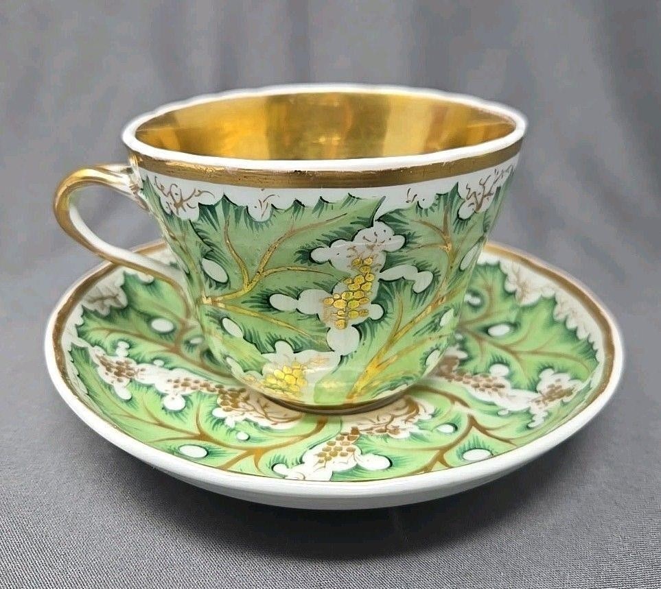 KPM Berlin Grapes And Leaves Pattern Cup & Saucer: KPM cup and saucer with large green leaves and gold grapes and gold interior. Slight scalloped edging on cup and saucer. Very good condition without chips or cracks. Some loss of gold, especially wher