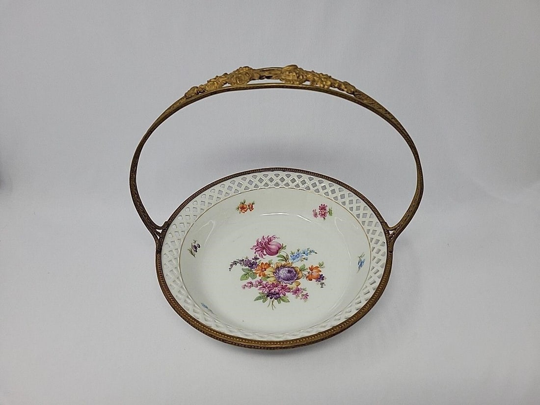 Schumann Basket Reticulated Metalwork Handle: Schumann Bavaria Germany reticulated basket with gilded metalwork handle. Circa 1932 to 1944. Dresden Style decorated. Measures approximately 8 5/8 inches diameter and 8 1/2 inches tall. No chips or c