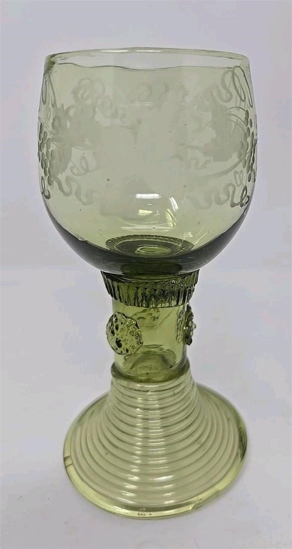 Green Glass Roemer, Applied Prunts c.1750-80: German Roemer in green. Applied raspberry prunts as well as a hollow coiled base. Circa 1750 to 1780. No chips or cracks. There is a glass string between two of the prunts. Rough pontil on base. Measu