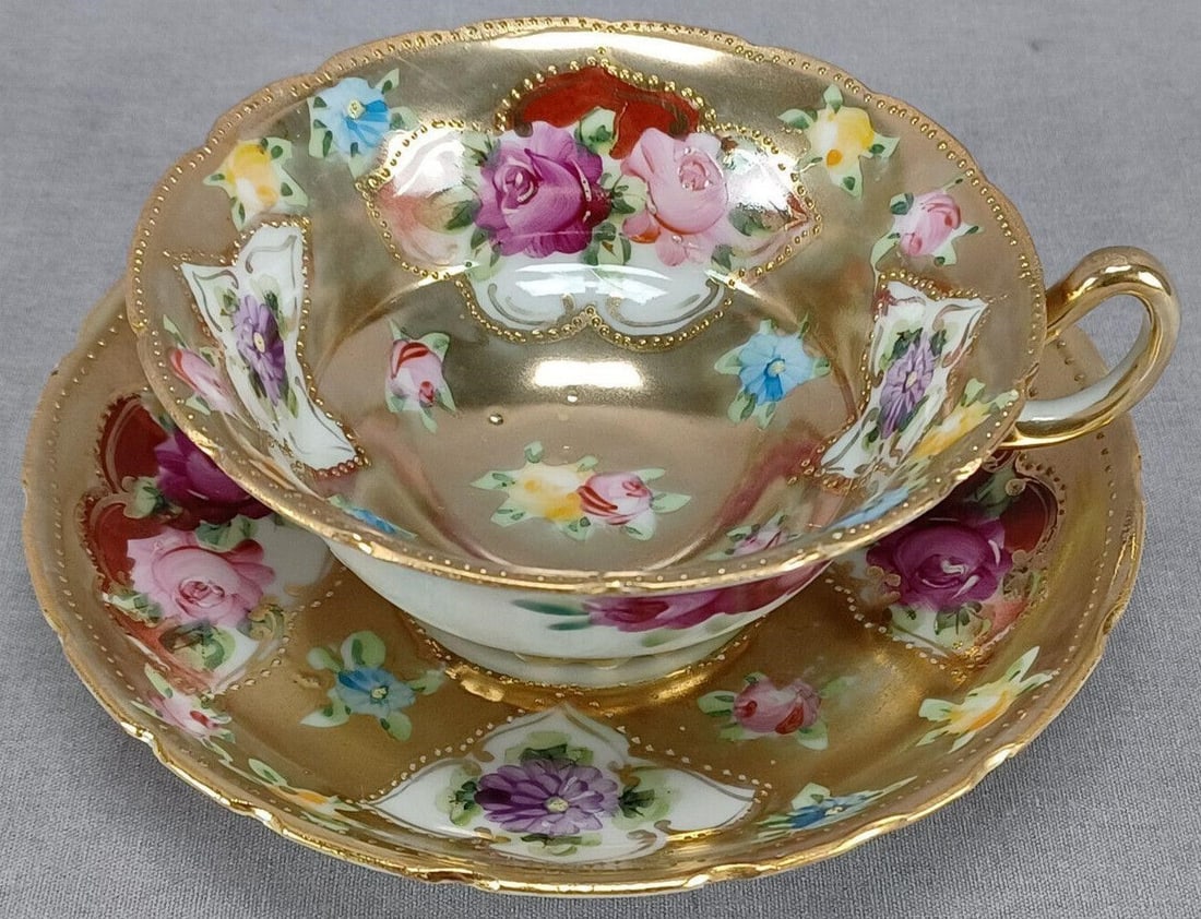 Nippon Hand Painted Floral Gold Tea Cup & Saucer D: Nice antique Japanese porcelain tea cup and saucer. The cup is decorated on the outside with dark pink roses. Decorated on the inside of the cup and on the saucer with hand painted pink and yellow ros