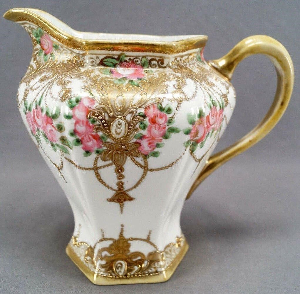 Nippon Pink Rose Gold Beaded & Scrollwork Pitcher: Antique porcelain pitcher. Nicely decorated with hand painted pink and gilt roses, with gold beaded garlands and raised gold gilt scrollwork. With beaded gilding along the edge. Marked on the bottom w