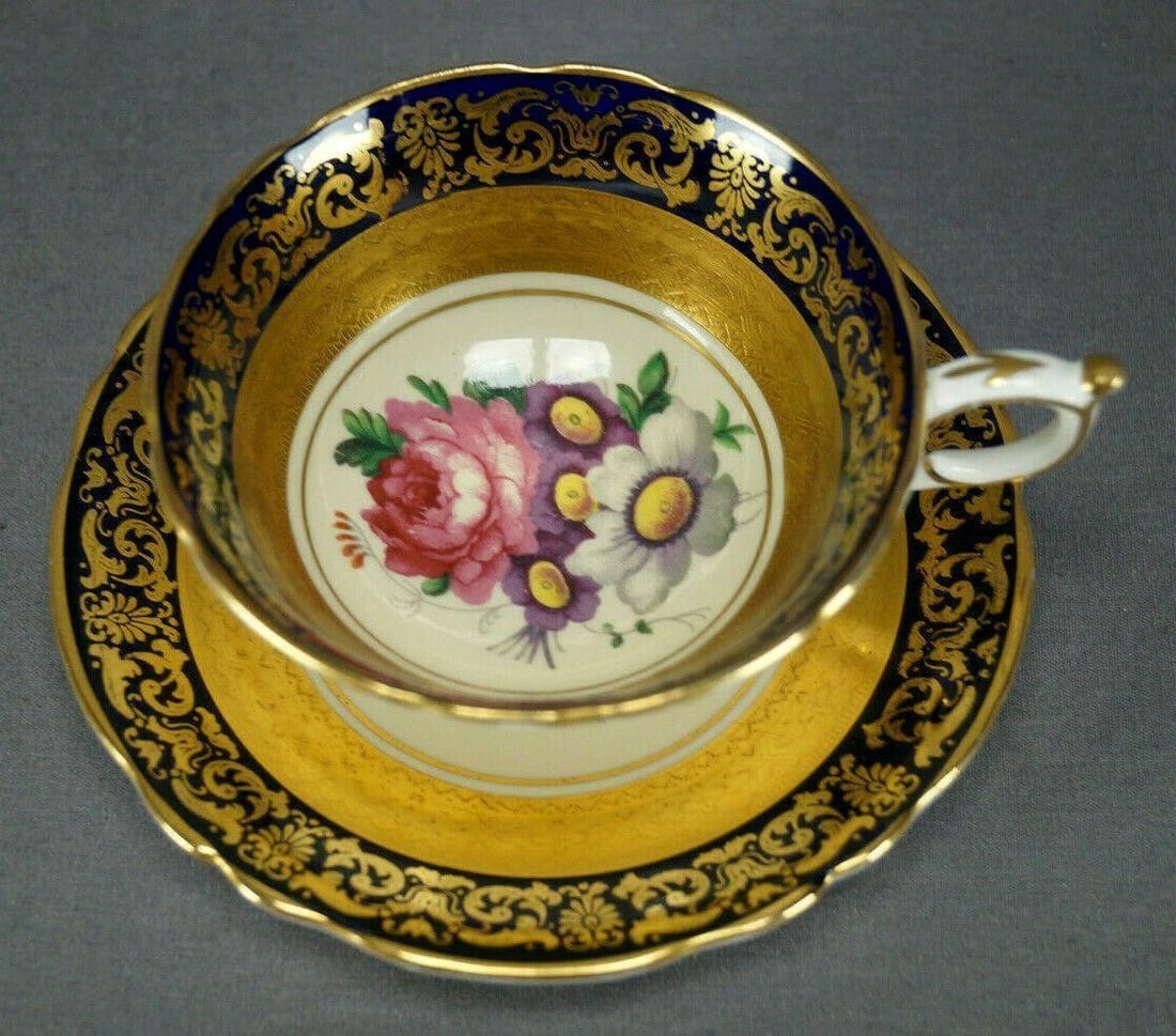 Paragon Pink Rose Cobalt Tea Cup & Saucer: Nice vintage bone china tea cup and saucer. The cup is decorated with a thin gold band around the center on the outside. Gold gilding around the bottom of the foot rim. The inside of the cup and the s