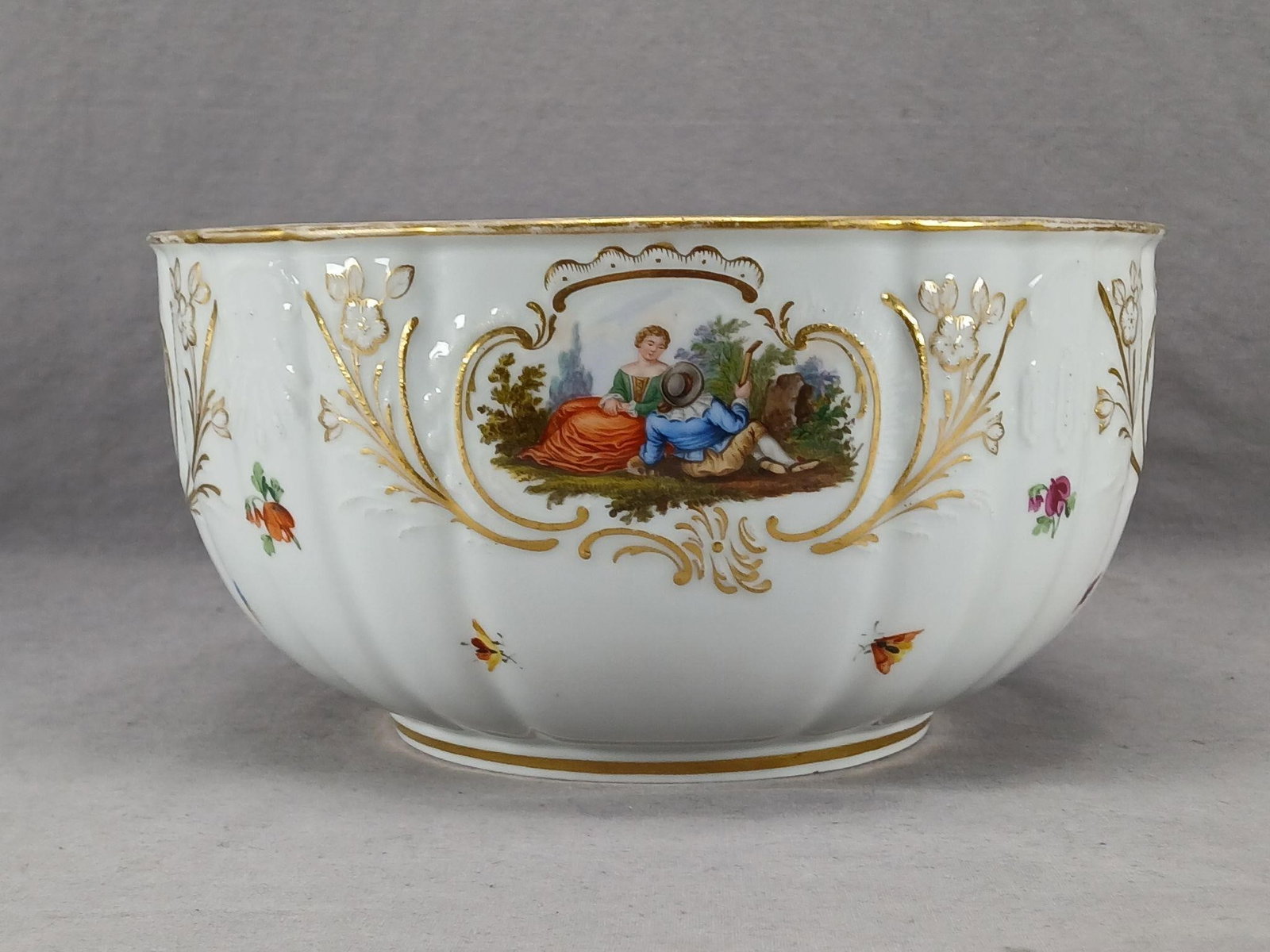 Meissen Watteau Scenes 9 1/4 Inch Bowl AS IS: Antique 19th century German porcelain bowl in the New Dulong pattern moulding. Decorated with hand painted Watteau courting couple scenes framed in gold scrollwork and flowers. With hand painted flowe