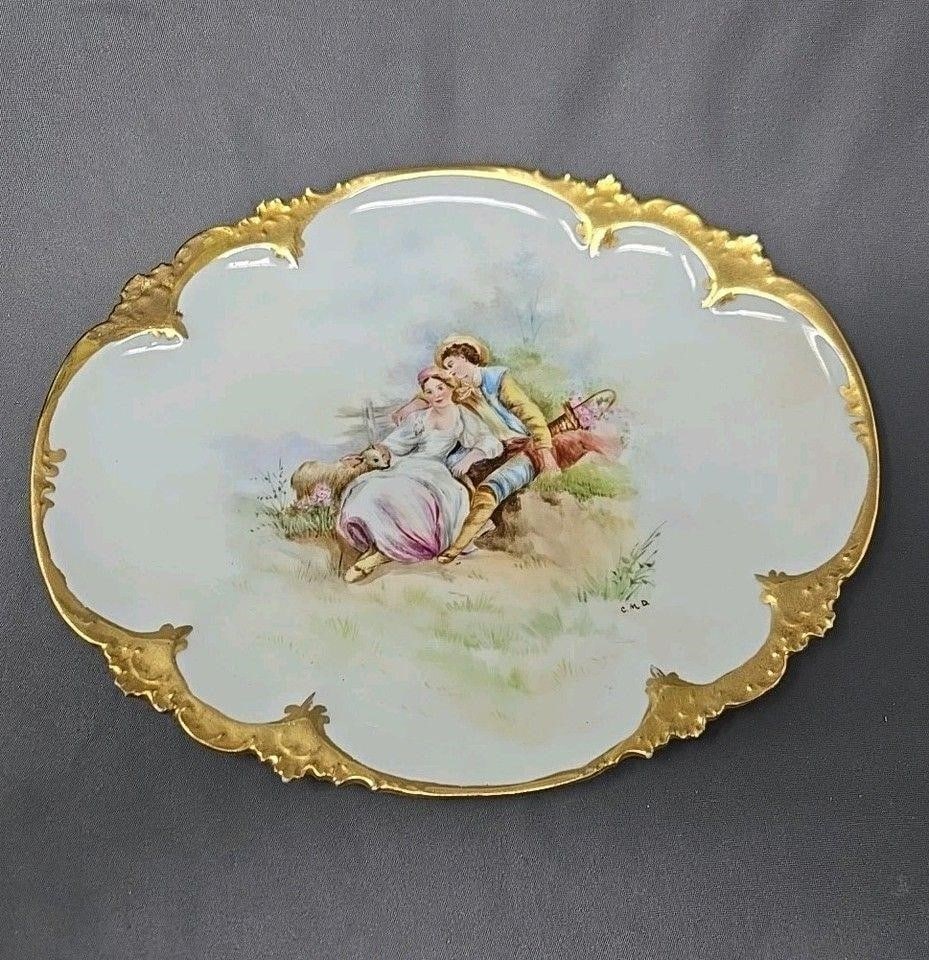 Limoges Hand Painted Tray Courting Scene Signed: GDA Limoges hand painted courting couple tray. Signed C. M. D. measures approximately 10 1/4 inches long and 8 inches wide. Some loss of gold on molded edges. Otherwise, there are no chips or cracks a