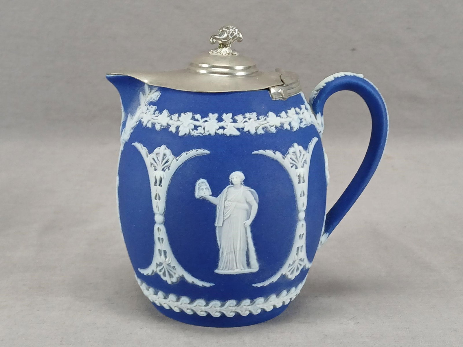 Wedgwood Jasperware Creamer / Pitcher C.1891-1908: Antique British dark blue and white jasperware creamer / small pitcher. White Neoclassical figures. Silverplate lid. Has an impressed Wedgwood England mark on the base. This mark was used between 1891