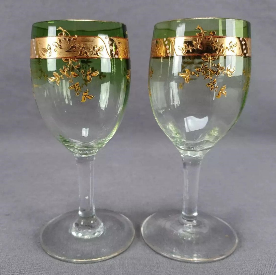 Pair of Signed Moser Green Claret Wine Glasses: Nice pair of antique hand blown optic molded green fading to clear claret wine glasses. Decorated with a band of gold gilding with white enamel beads and raised gold floral designs. Signed on the bott