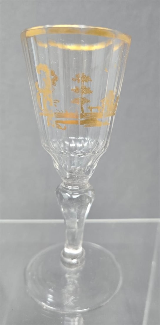 Cut Glass and Gilt Continental Wine Glass 18th C.: Unmarked Continental wine glass from the late 1700s. Gold gilt pattern on a molded glass with a cut stem. Measures approximately 5 1/2 inches tall and 2 inches in diameter. There are flake chips on th