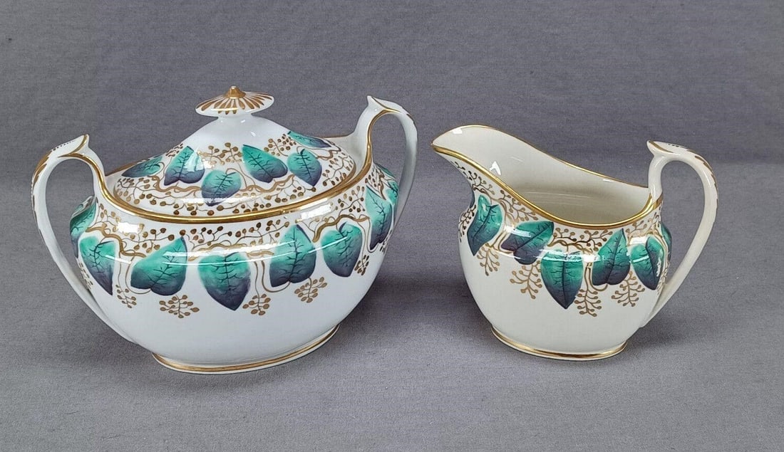 Machin Pattern 148 Creamer & Sugar Circa 1800-1815: Nice antique British bone china creamer and sugar. Decorated in Machin's pattern 148 with green leaves and gold. Marked on the bottom with the patter number 148. Circa 1800 to 1815.Both have some craz