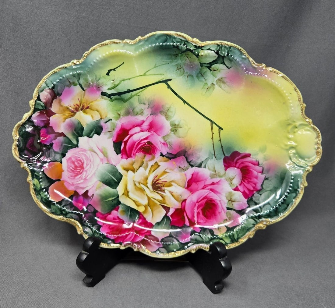 Austrian / German Oval Tray with Large Roses: Unmarked tray with large pink and yellow roses and a molded edge. Gold gilt with beading on rim. Measures approximately 12 3/4 inches long and 9 1/4 inches wide. no chips or cracks, there is some loss